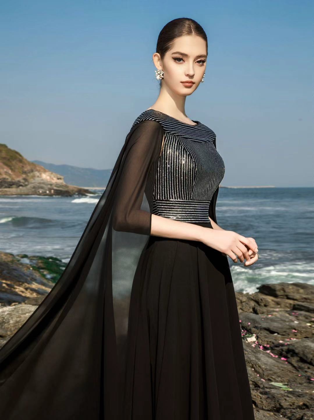 Schwarzes, von Hand veredeltes Abendkleid, fotografiert am Meer